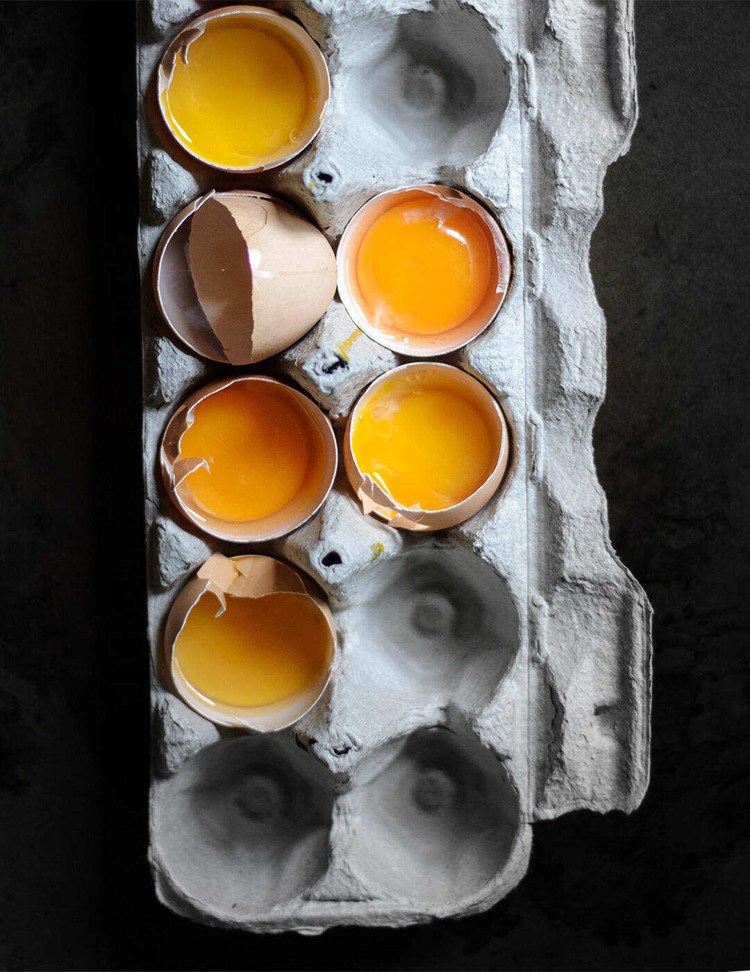 Cracked eggs in an egg carton.
